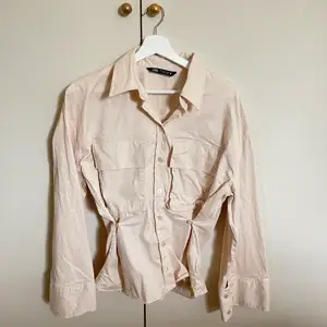 En ljusbeige skjorta från Zara som går in vid midjan och som har breda/vida armar. Aldrig använd. Säljer för 100kr + frakt.