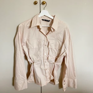 Beige skjorta från Zara, strl. S - En ljusbeige skjorta från Zara som går in vid midjan och som har breda/vida armar. Aldrig använd. Säljer för 100kr + frakt.