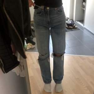 Ett par blåa ginatricot jeans med hål på båda knäna. Andvända några gånger och i str 32. Köparen står för frakten.💙