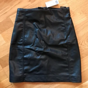H&M kjol i skinnimmitation strl 36 - Oanvänd kjol med lapp kvar, strl 36. Lite liten på mig då jag har blivit en 38:a!
