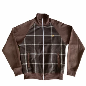 Fred perry tracktop - Brun fred perry tracktop med rutigt mönster i perfekt skick. Säljer för att den är för liten.