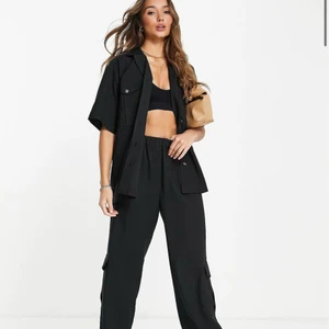 Svart set  - Svart cargoskjorta med korta ärmar samt matchande byxor i använt skick, köpta från ASOS förra året, slutsålda på hemsidan! :) Nypris var runt 1000kr, säljer skjortan och byxorna tillsammans för 450kr + frakt <3