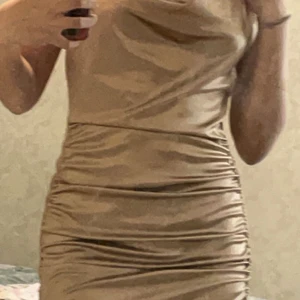  klänning  - Säljer min guldfärgade klänning från h&m,storlek storlek S. Det går att justera snörena på sidan så den sitter enligt hur du vill ha den.