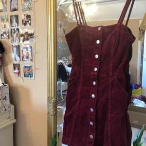 Vinröd klänning - Vinröd klänning från HM divided. Använd enstaka gånger men i väldigt bra skick. Väldigt fin att använda med en skjorta under, men lika fin utan. 