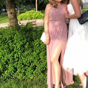 Balklänning  - Supersöt balklänning, en lång slits vid benet. Kristaller/ pärlor kring hela axelbandet. Öppen i ryggen. Bra skick. Smutsrosa, storlek 36