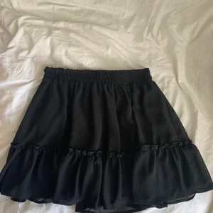 Svart kjol - Säljer en svart jättefin kjol med volang i fint skick 