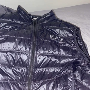 Ea7 väst herr - Använd 3 gånger max riktigt bekväm och smidig med innerfickor den är inte jätte varm så man kan ha den på sommaren. Nypris 1600.