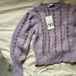 OANVÄND tröja Zara - Stickad tröja från Zara, helt oanvänd i storlek M. Köptes för ca 2 år sedan, men inte riktigt min stil! Lite glitterdetaljer, lila och väldigt långa, härliga ärmar! Perfekt för att liva upp outfiten litegrann💃🏼😍  (frakt tillkommer)