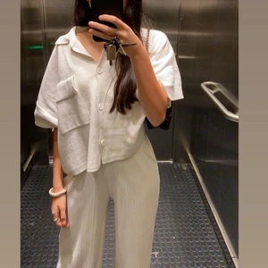 Plisserade byxor - Långa vita byxor i plisserat tyg. Slutsålda på Gina. Storlek XS men passar S med.