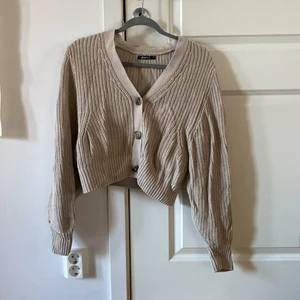 Beige stickad kofta - Beige stickad kofta från Gina Tricot. Använd ett par gånger men ändå bra skick. Nypris 499kr