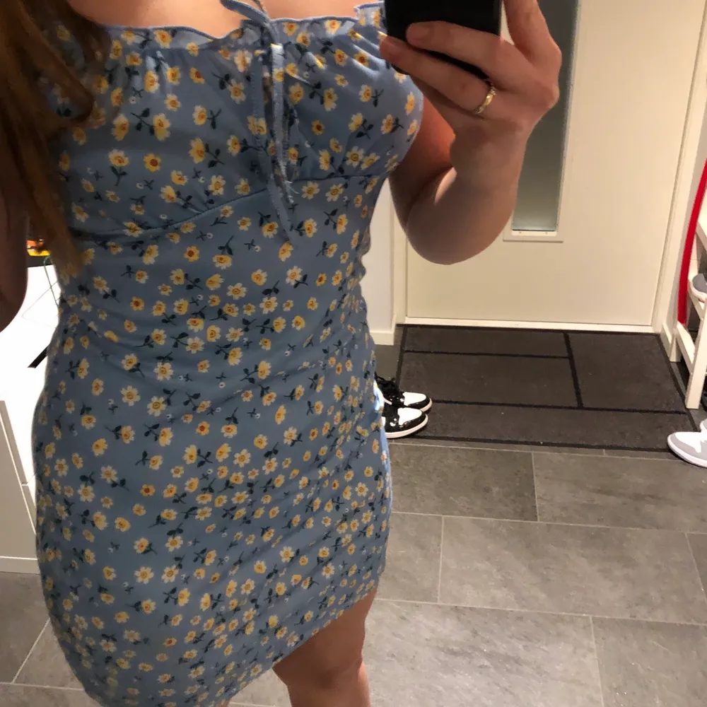 Jättefin blå klänning med gula blommor som tyvärr inte kommer till nån användning. Storlek XL men passar bra för mig som har M, så den är ganska liten i storleken. Köparen står för frakt!. Klänningar.