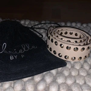 Gabrielle By P väskband! ÄKTA - Ett sjuuukt snyggt äkta Gabrielle by P beige väskband med nitar. Äskar det här väskbandet men kommer inte så mycket till användning. Köpt för ca 700 men säljer för 500 som startpris då det knappt är använt. Passar perfekt till den Bruna skinn Majeväskan jag säljer här på plick också. Den har en liten skada lite längre ner på bandet som ni ser på bild 3 men det syns knappt. Original ”påsen” ingår. Buda!!! (Skriv priv för fler bilder)