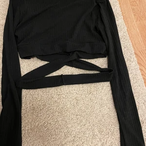 Topp med snöre ish - En svart topp med ish snöre som ska få som ett kors under brösten. Köpt på boohoo för 140kr, endast prövad då den inte passar min byst. Storlek S. Köparen står för frakten!