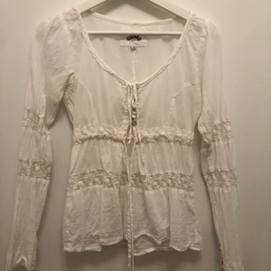 Blus från Fira - Vit blus från Fira i storlek S med spetsdetaljer, knytdetaljer och knappar. Nypris 999:-, säljes för 150:-. I väldigt fint skick 🌸