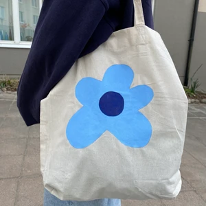 Tygkasse - Fin tygkasse jag målat på själv! Perfekt till sommaren💕 Den är 40x40 plus har en innerficka som är perfekt att ha tex mobil elr nycklar i!💕 Kolla gärna in min profil för andra påsar och kläder jag säljer :) Budgivning om flera är intresserade (buda minst 10kr mer) vinnande bud får lägga till valfri text om den vill