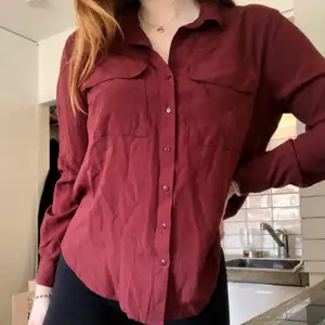 En rödvinsfärgad skjorta i viskos. Två fickor på framsidan. Bra skick och är perfekt och tunn till sommaren. Köparen står för fraktkostnader.