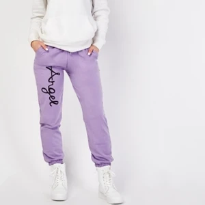 Lila mjukisbyxor  - Helt nya lila mjukisbyxor med "angel" skrivet på ena benet. De är low waist men går absolut att dra upp och använda som mellan till hög midja. De har fickor och är sköna. Inte min bild men kan skickas fler om det önskas! De är I storlek 14-16 xl men passar m till l även s om man vill ha de lite mer baggy.