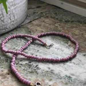 Ett rosa pärlhalsband med spänna som jag gjort själv. Halsbandet är ca 40 cm långt.