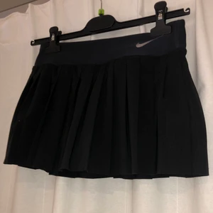 Veckad Nike Tenniskjol - Söt veckad tenniskjol från Nike. Säljer då jag har vuxit ifrån den. Som tredje bilden visar är det en M för 10-12 år, säljer för 80kr, frakt tillkommer. hör av er vid fler frågor :) 