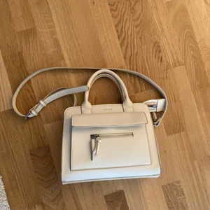 Väska NA-KD  - Vit/offwhite väska med handtag och axelrem. Fint skick både utvändigt och invändigt 