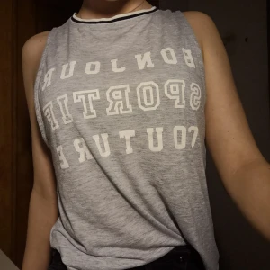 Ljusgrått löst linne storlek S - Ljusgrått linne med fransk text "Bonjour sportif couture". Storlek S