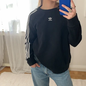 Adidas tjocktröjai storlek 34 - Nästintill oanvänd adidas tröja, svart med streck längs armarna. Lite ovensize, i storlek 34. Orginal priset ligger på omkring 500kr. ❤️