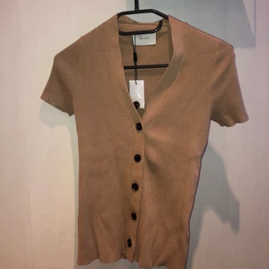 Tröja med knappar - Ribbad brun T-shirt med knappar. Passar en storlek 34 och 36. Oanvänd.