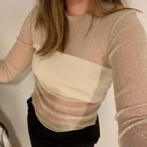 Guldglittrig meshtopp  - Guldglittrande festtopp i mesh. Säljer då den inte kommer till användning och är i mycket fint skick. Hör gärna av dig vid frågor, priset kan diskuteras