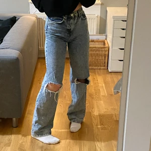 Blå jeans med hål på knäna - Underbara jeans från NA-KD, sitter väldigt bra. Är i bra skick i storlek 36.