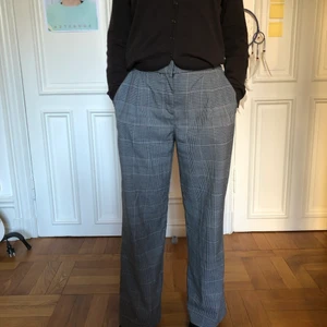 Monki kostymbyxor strl38 - Rutiga Kostymbyxor från Monki. Högmidjade och vida i benen. Fickor framtill och en fakeficka där bak. Strl 38