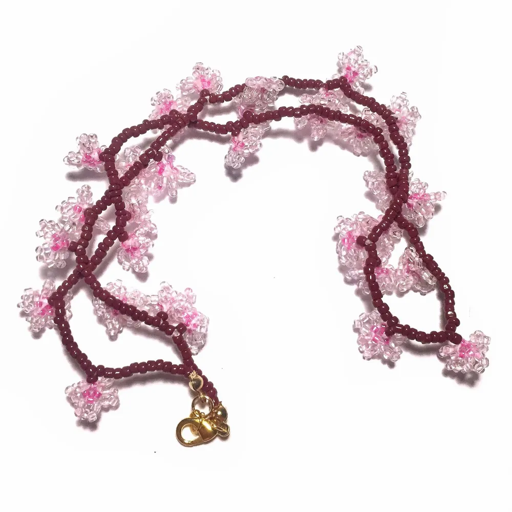 Handmade glass bead necklace with cherry blossom design. Accessoarer.