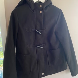 Höstjacka med luva, storlek S - Svart jacka med luva, dragkedja och knappar. Perfekt höst/vår jacka, kanske även vinter. Storlek S men skulle kunna passa en medium också då den är lite boxig i modellen. 