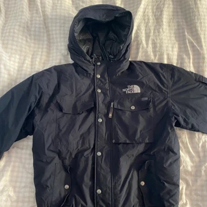 North Face dunjacka - Säljer min dunjacka från North Face. Snygg och varm. Enda anmärkningen är att knappen på ena bröstfickan är borta. En lätt åtgärd om man har orken. Se bild. I övrigt toppenskick.  Finns o hämta i Stockholm. Kan även skickas mot betalad frakt. Det står att det är storlek L men passar mig som är en medium. :)