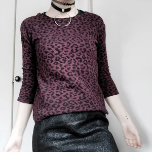 Leopardmönstrad tröja 🖤 - En burgundyfärgad tjocktröja med svart leopardmönster. Den har en dekorativ dragkedja på ena sidan 🥰 Simpel och snygg!! Storlek 34 men stor i storleken, passar upp till en liten medium beroende på passform 😌  40kr