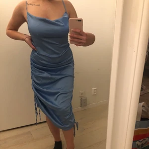 Klänning - Blå klänning i satin material i från shein. Perfekt festklännig som du kan justera på båda sidorna, antigen kan du ha den lång eller att den är sne. ( Se bilder ) Köparen står för leverans☺️ Aldrig använd. Säljer pågrund av att jag inte tyckte klänningen var riktigt jag! 🤍 