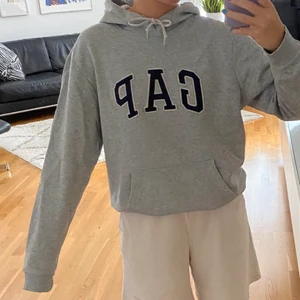 GAP hoodie - Mysig grå gap-hoodie! Storlek Medium, den är egentligen längre men jag tycker att det är snyggt att ha den lite uppvikt. Köparen står för frakten! 🐻💕