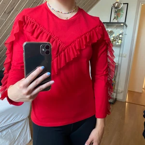 Tröja med volanger  - Röd tröja från Monki med volanger. Jätteskön och i nyskick! Hör av er vid frågor eller om ni vill ha fler bilder❤️