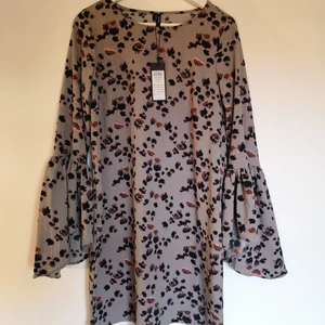 Mönstrad sommarklänning - Mönstrad klänning i dämpad rosa färg med volang i ärmen från vero moda. Storlek S. Oanvänd. 