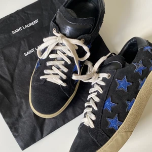 Saint Laurent sneakers  - Jättefina sneakers från Saint Laurent. Svart mocka med blå/silvriga stjärnor. I fint skick! Kommer med två stycken dustbags en för varje sko. Storlek 39. Köpta secondhand men är tyvärr för små. Skriv gärna om ni vill ha fler bilder eller har frågor!