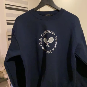Mörkblå sweatshirt  - Min favorit sweatshirt från boohoo , super fin med ett jätte fint tennis tryck och dessutom jätte mysig ! Storlek , har varit favoriten länge men väljer nu att sälja den✨ fläck som kom i tvätten längst ner vid tröjan men går att vika upp tröjan eller bara har den som den är ;) skriv vid intresse 