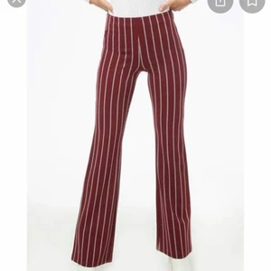 Vinröda vida byxor med ränder - Vinröda vida byxor köpta på forever 21 i newyork💕. Storlek S och sitter vanligt i längden och har även en dragkedja på sidan av midjan. Använda endast en gång så säljer då jag ej använder. Köparen står för frakt!