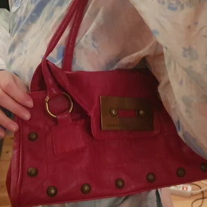 Röd väska - Köpt sh. Står dolce&gabbana på den men troligtvis inte äkta. Fin, helt ok kvalité. Lite missfärgad på insidan. Mässingdetaljer