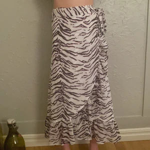 Omlottkjol - Personen här är 150 så kjolen kommer inte vara så lång på dig. Men det är iallafall en omlottkjol med zebra mönster i lilla, vitt och svart. Eftersom det är en omlottkjol så passar den allt ifrån xs till m skulle jag säga. Den passar både mig och min syster. 