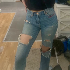 Jeans i storlek 36 - Blåa slitna jeans med texten ”girls bite back” vid ena fickan i storlek 36. Frakt ingår ej i priset.