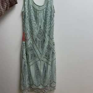 Festklänning  - Klänningen är köpt i London för 2 år sedan, köpt för 1200 och säljer för 200 pga att den är för liten. Klänningen är sönder vid dragkedjan. Det går att stänga om man är försiktig, tar lite tid kanske. flera bilder kan skickas:)