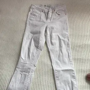 Vita jeans från gina tricot, storlek 36. hål i knät.