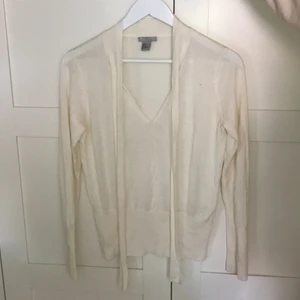 Vit tröja från HM - En vit tröja från hm med snörning vid halsen om man vill ha de eller bara fint med de hängande:) jag säljer denna då den inte kommer till användning längre