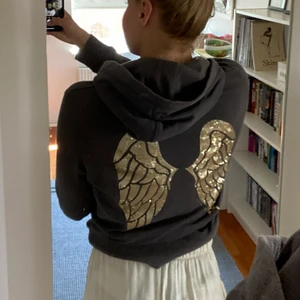 VS hoodie - Mörkgrå hoodie från Victorias secret som inte går att få tag på längre. Guldiga vingar på ryggen och guldiga vingar vid vänster ficka på framsidan. Storlek M💕 Supermjuk och bra skick!