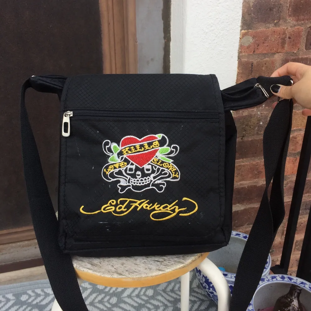 Jätte cool Ed Hardy väska som är väldigt rymlig och har många fack/fickor. Skit bra att ha dator/ skolböcker i. Inga synliga fel förutom att det är lite klotter på baksidan av den stora fickan, så det syns alltså inte alls förutom om du öppnar väskan. Går att måla över om man stör sig på det. Säljer pga att jag inte använder längre. Skriv bud privat. Bud från 400. Laukut & Käsilaukut.