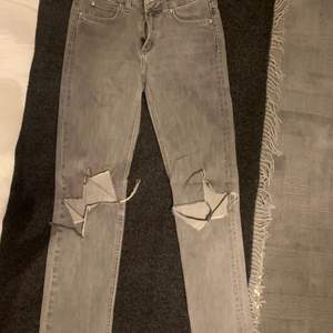 Jag säljer dessa gråa jeans från Acne med hål på knäna. De är i storlek 26/32 och är perfekt längd för mig som är 169. Anledningen till varför jag säljer dem är för att de har börjat bli lite för små på mig. 